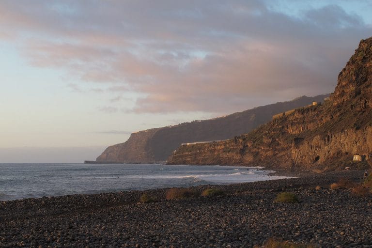 Steile vulkanische kliffen boven het rotsige strand Playa Guirros bij Tazacorte op La Palma bij zonsondergangslicht