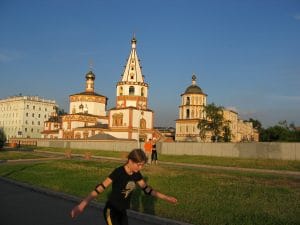 Witte Russisch-orthodoxe kerk met gouden uikoepels en kleurrijke klokkentoren in het centrum van Irkutsk