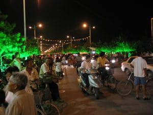 Verlichte avondstraat in Hohhot met kleurrijke slingers en voetgangers in de zomeravond