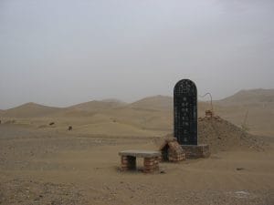 Chinees grafmonument met Chinese karakters in de zandduinen bij Dunhuang, woestijnbegraafplaats