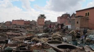 Panoramisch uitzicht over de leerlooierijen van Marrakesh met dierenhuiden, werkers en okerkleurige gebouwen van de medina