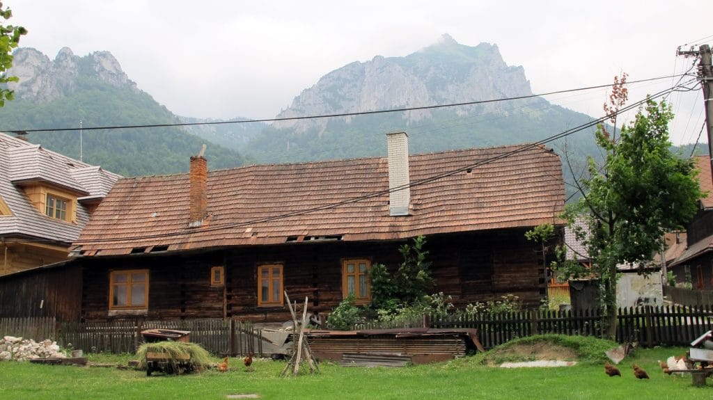 Traditioneel houten huis met pannendak in Stefanova, op de achtergrond de rotsige toppen van de Malá Fatra, Slowakije