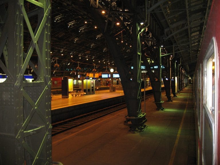 Interieur van Köln Hauptbahnhof 's avonds met de stalen dakconstructie en verlichte perrons, tijdens wachten op de trein naar Praag