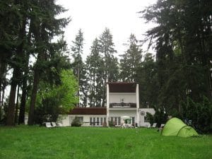 Hoge dennen- en sparrenbomen in de tuin van een pension in Vyžlovka, Tsjechië, campingplek tijdens de fietsetappe vanuit Praag