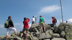Groep wandelaars op de rotsige top van Mount Chopok (2.024 m) in de Nízke Tatry met wegwijzerpaal, Slowakije
