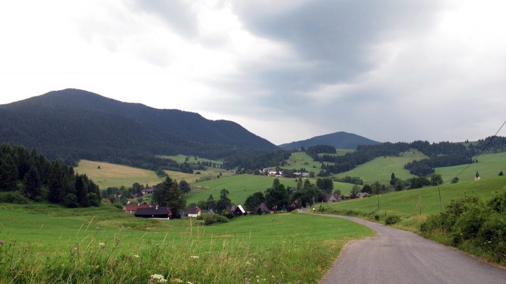 Groen bergdal met verspreide huizen van Veľké Borové, omgeven door beboste heuvels in de Kvacianska Dolina, Slowakije