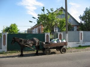 Bakstenen woonhuis met boom en satellietschotel in Komarhorod, Oekraïne, waar 's ochtends verse melk wordt opgehaald