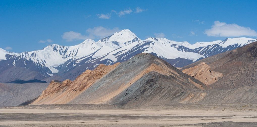 Colorfull mountains and snowcapped mountains around the dessert landscape of the Pamir Plateau