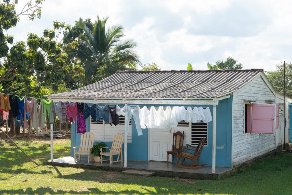 Eenvoudig Cubaans landelijk huisje met golfplaten dak en wasgoed aan een waslijn voor het huis