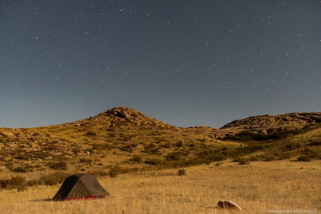 Tent op een kale rotsachtige steppe in Kazachstan onder een donkerblauwe nachtlucht vol sterren