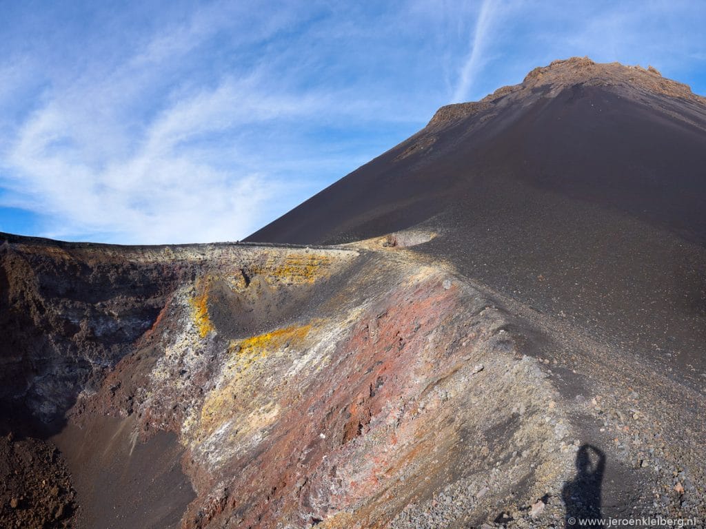 Uitzicht op de kleurrijke kraterrand van de Pico do Fogo op eiland Fogo in Kaapverdië, met gele en rode mineraalafzettingen langs de vulkaankegel