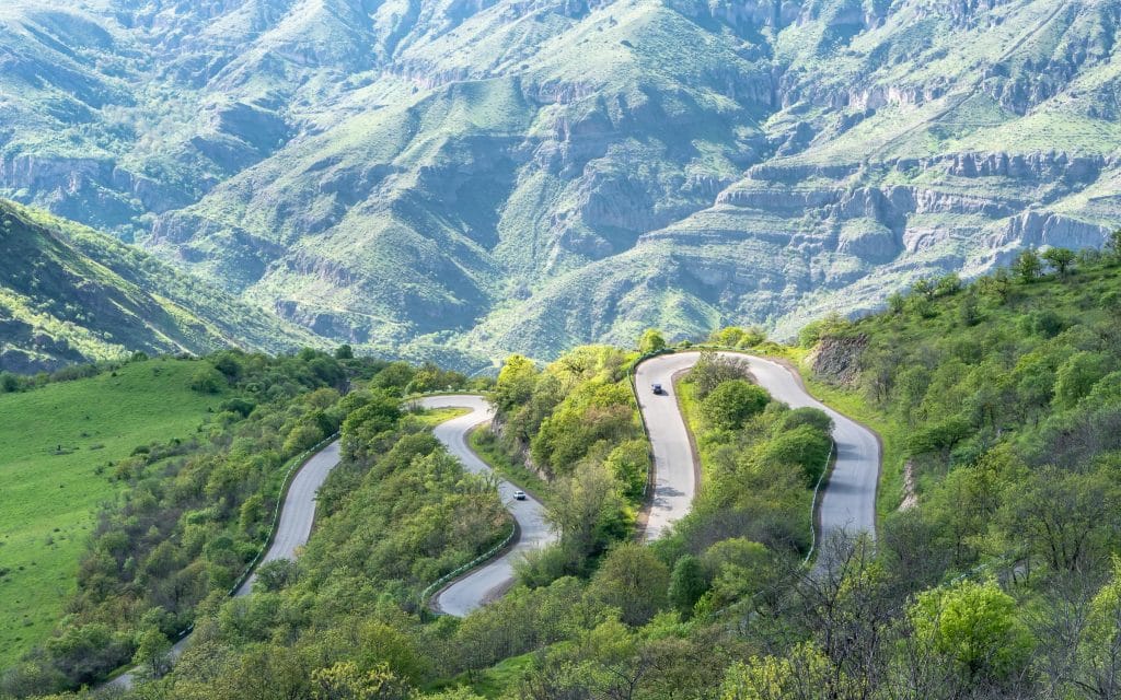 Kronkelende bergweg door een diepe groene kloof in de provincie Syunik, Armenië