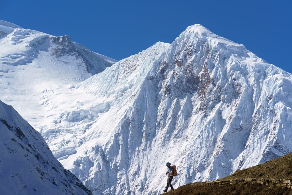 IJzig pad door een besneeuwde vallei op het Manaslu Circuit in Nepal met bergtoppen op de achtergrond