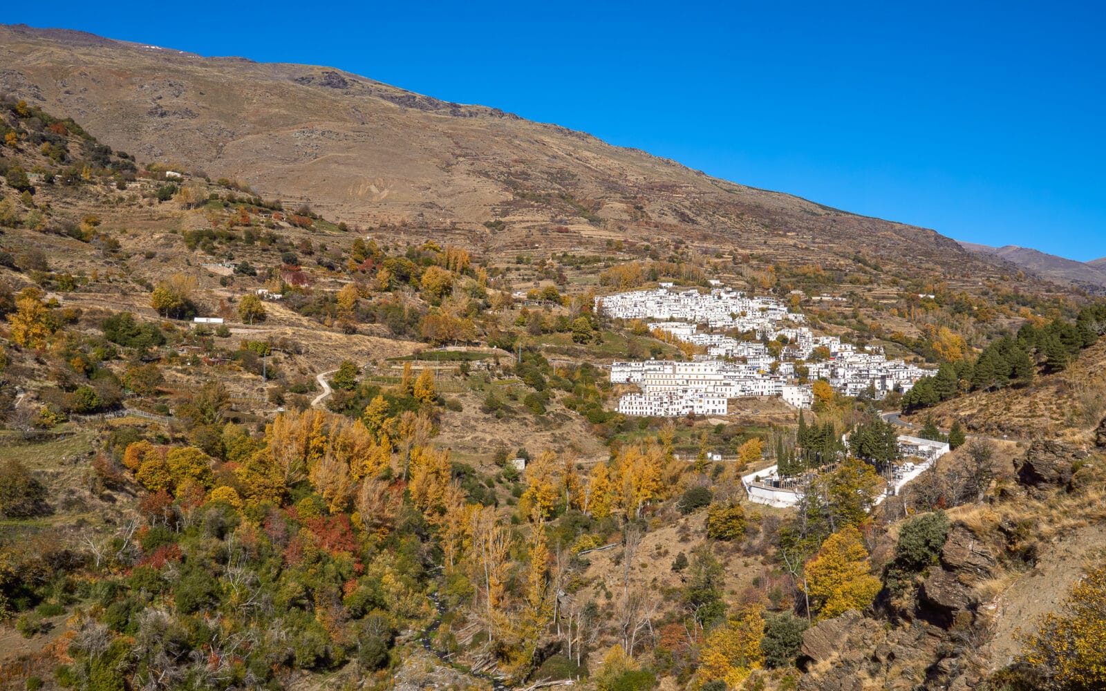 Het witte bergdorp Trevélez tussen de herfstkleuren in de Alpujarra