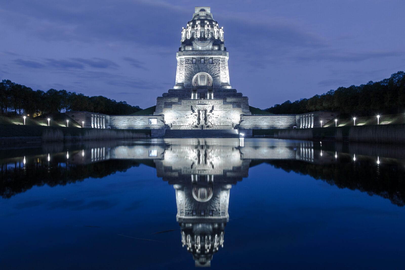 Het Völkerschlachtdenkmal weerspiegeld in het waterbassin in het blauwe uur, Leipzig
