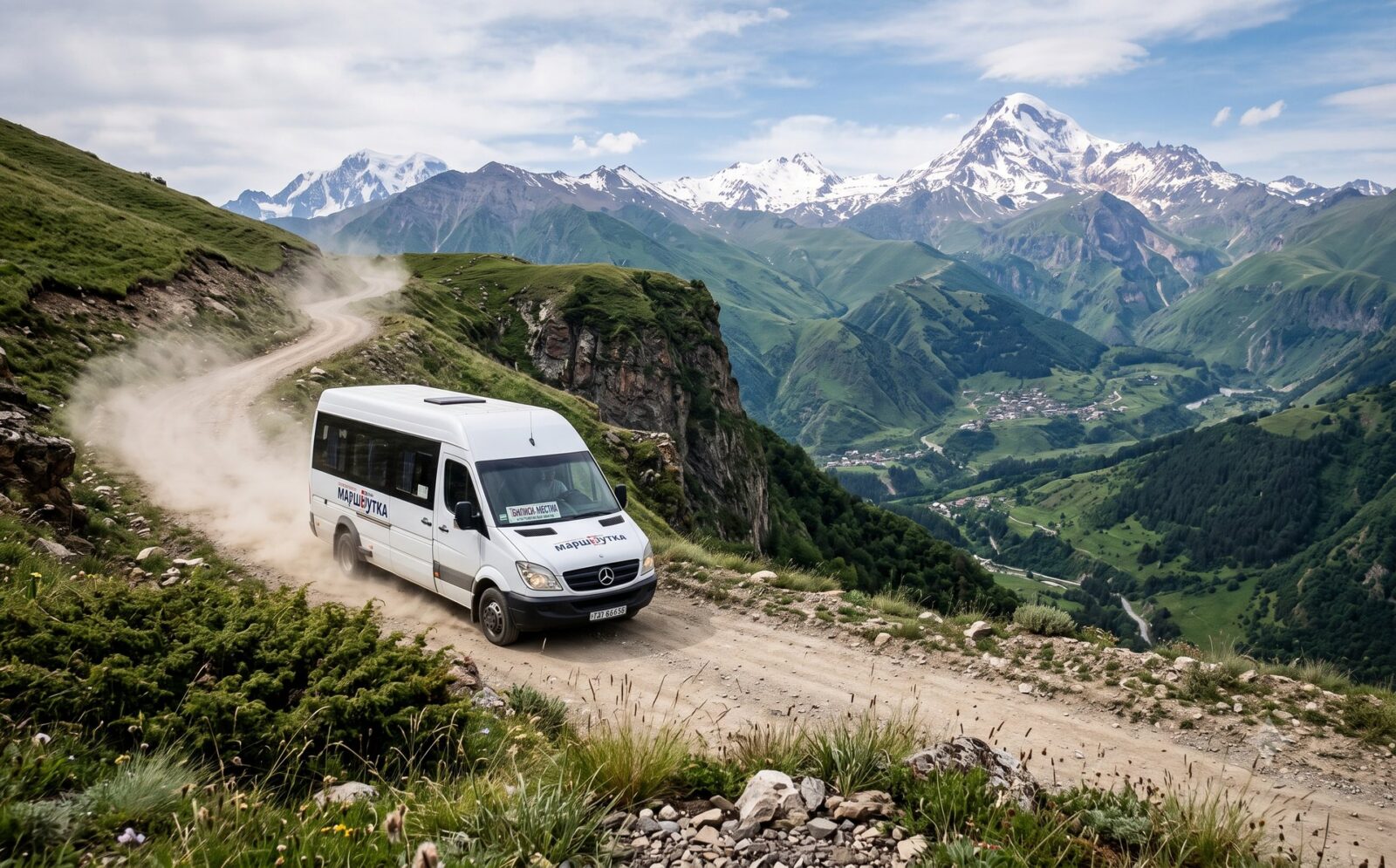 Witte marsjroetka-minibus op een smalle bochtige bergweg door de Grote Kaukasus met groene dalen en besneeuwde toppen