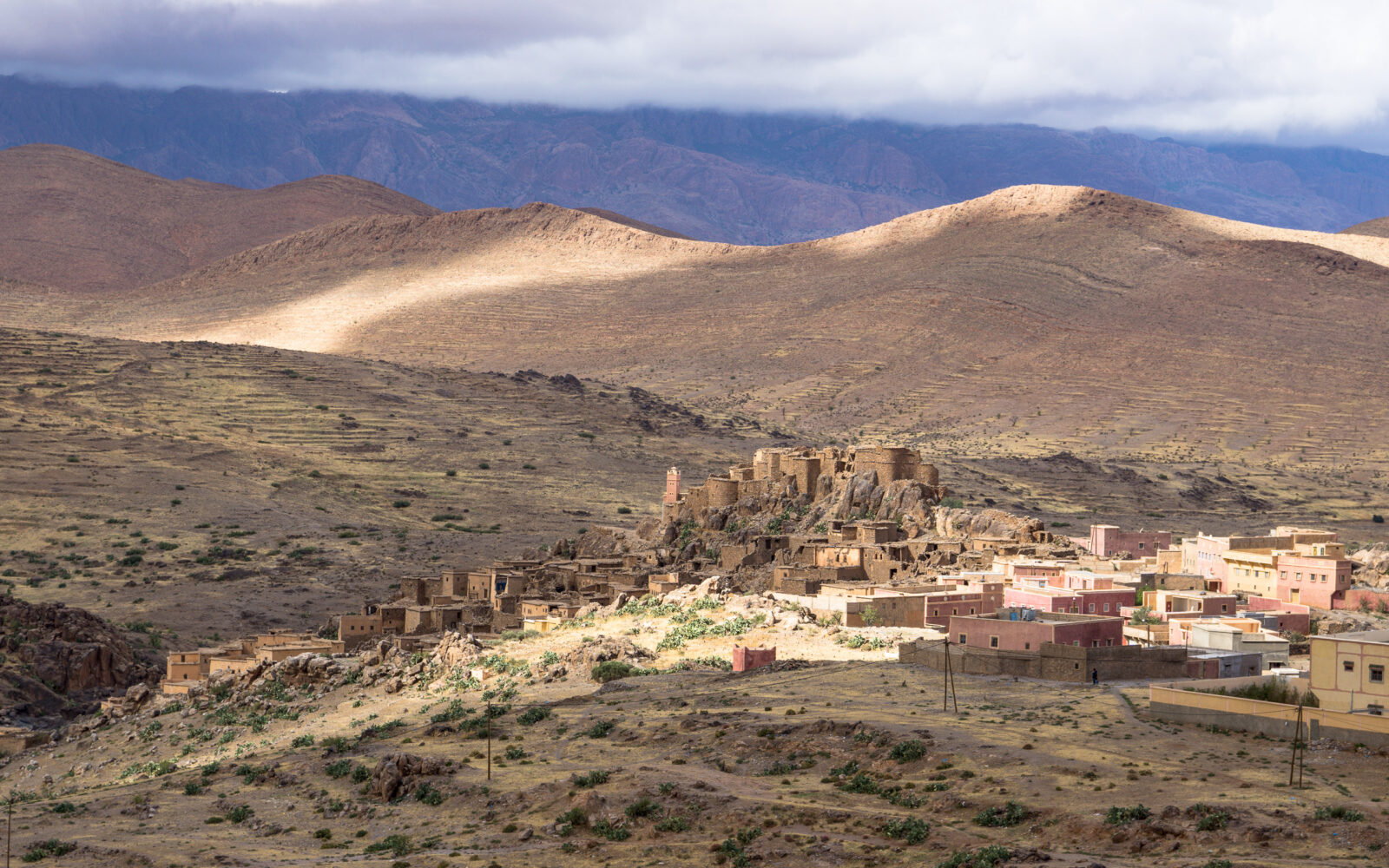 Sunlight illuminates ancient village nestled in rugged mountains