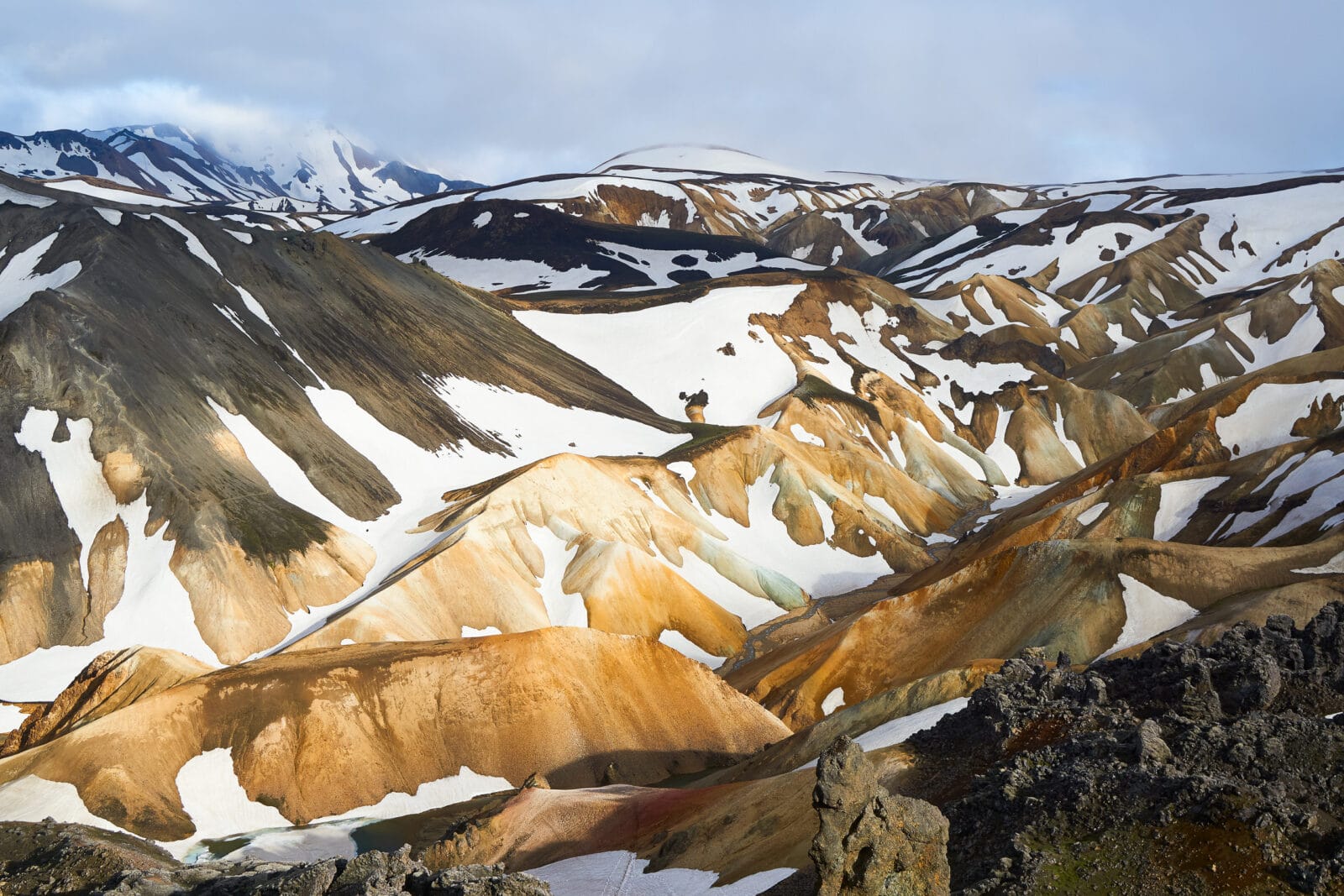 Sneeuwresten op de gekleurde ryolietbergen van Landmannalaugar