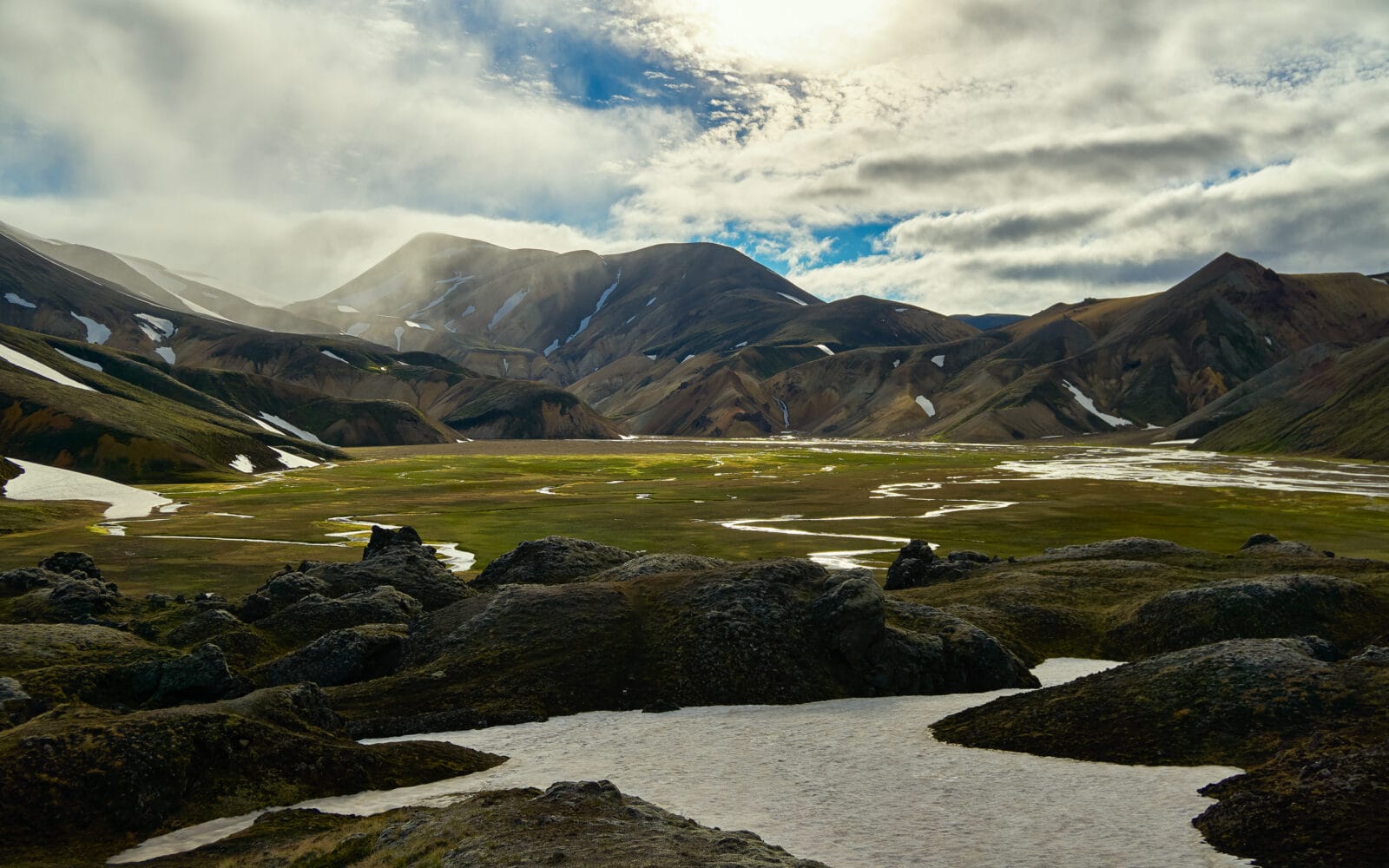 Zonlicht door de wolken boven het rivierdal bij Landmannalaugar