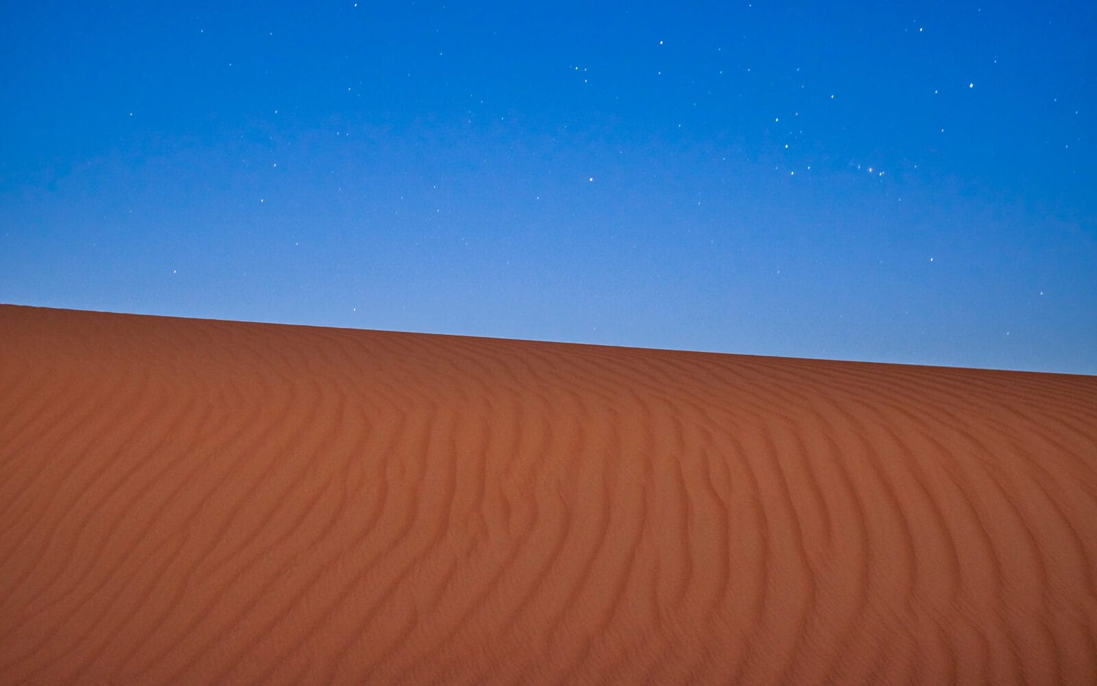 Duinen onder een sterrenhemel in de Wahiba-zandwoestijn