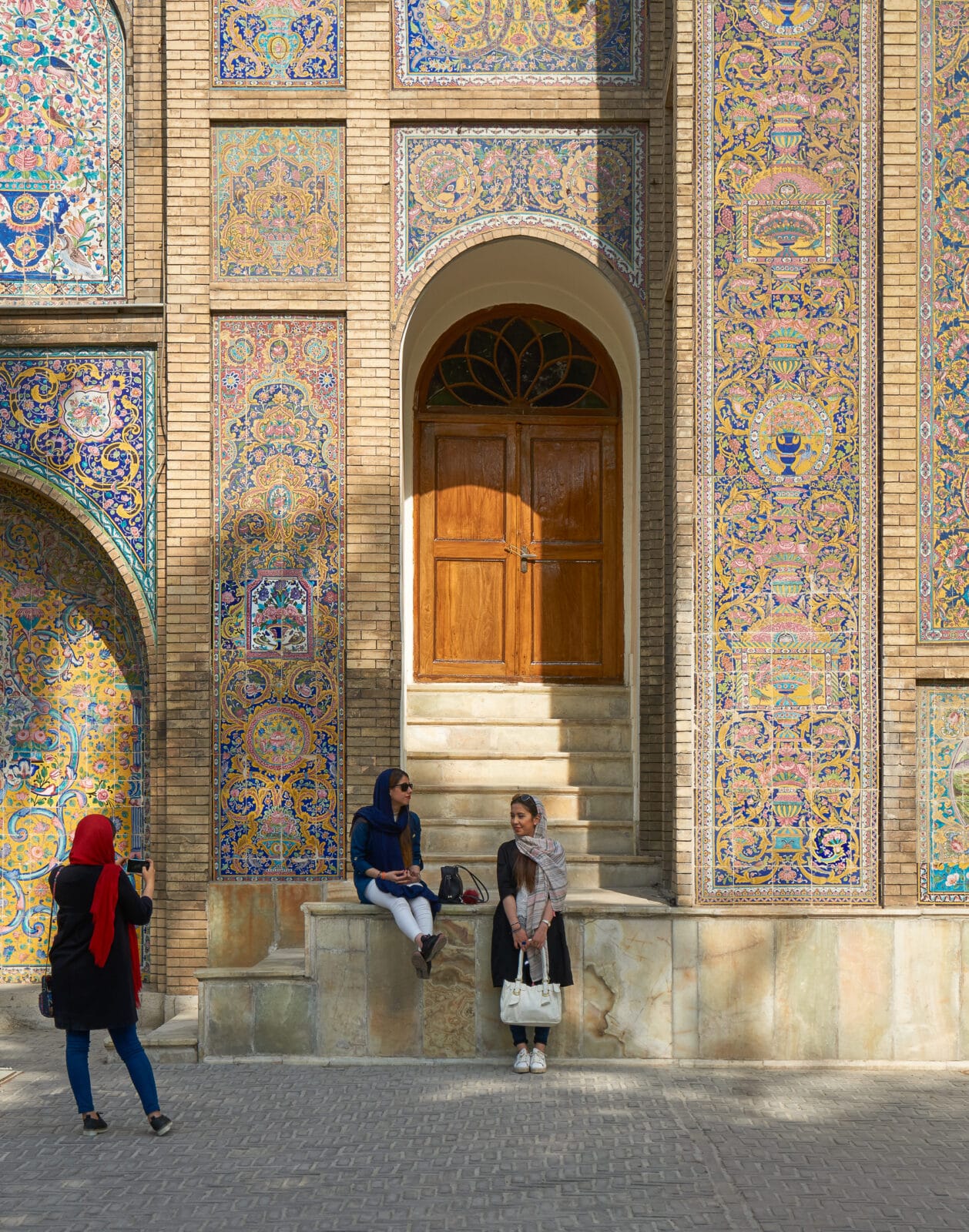 Vrouwen bekijken het tegelwerk van een moskee in Teheran