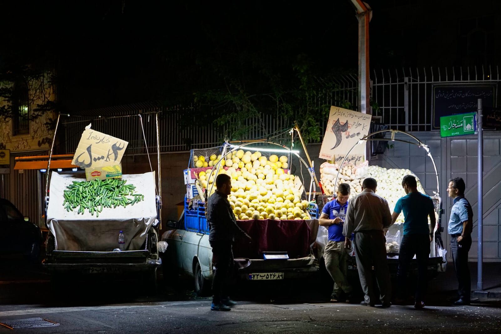 Groentekramen onder felle lampen op de avondmarkt in Teheran
