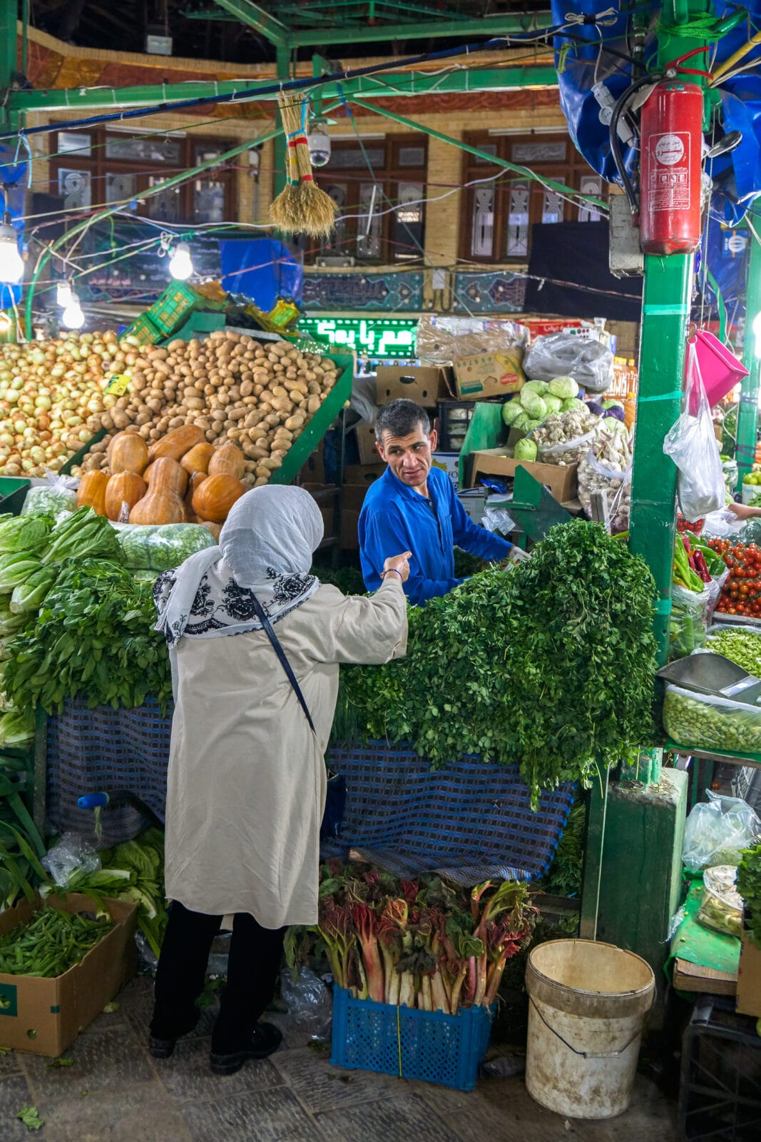 Vrouw koopt groente op een markt in het noorden van Teheran