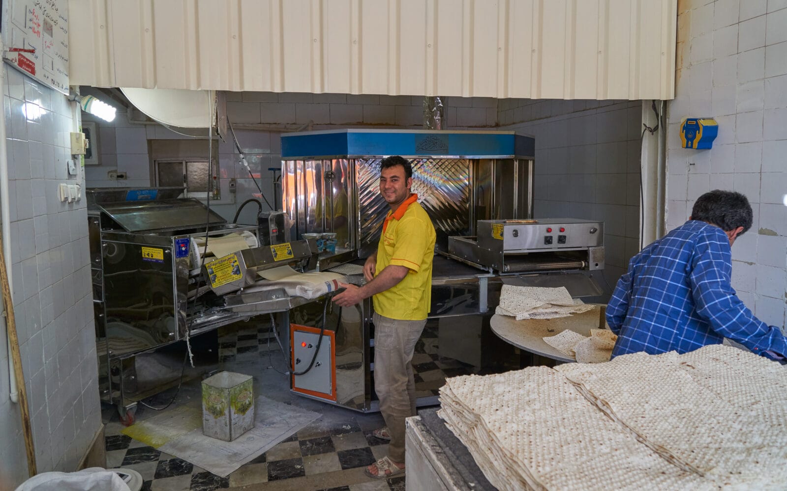 Bakker lacht bij zijn deegmachine in Shiraz