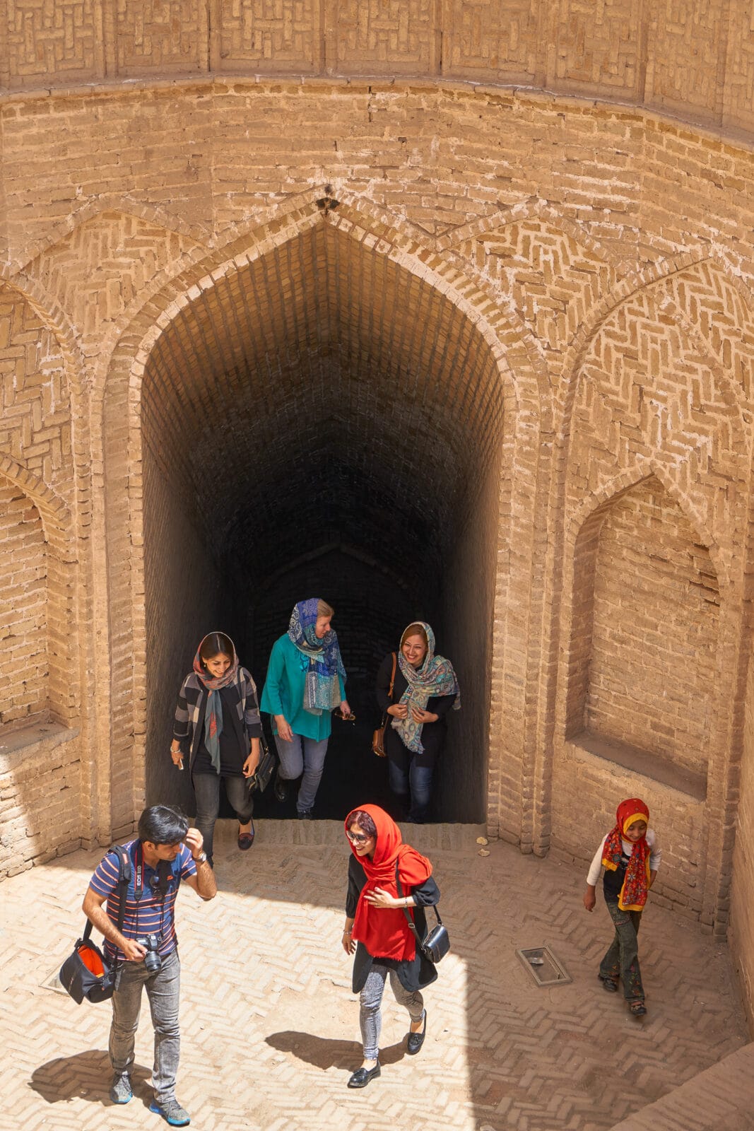 Vrienden onder een oude bakstenen boog in Yazd