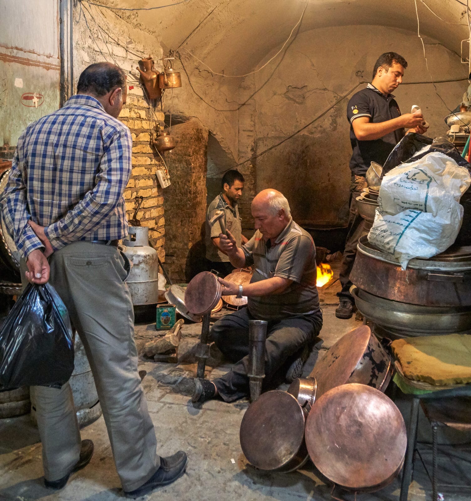 Kopersmid in zijn schemerige werkplaats in Yazd