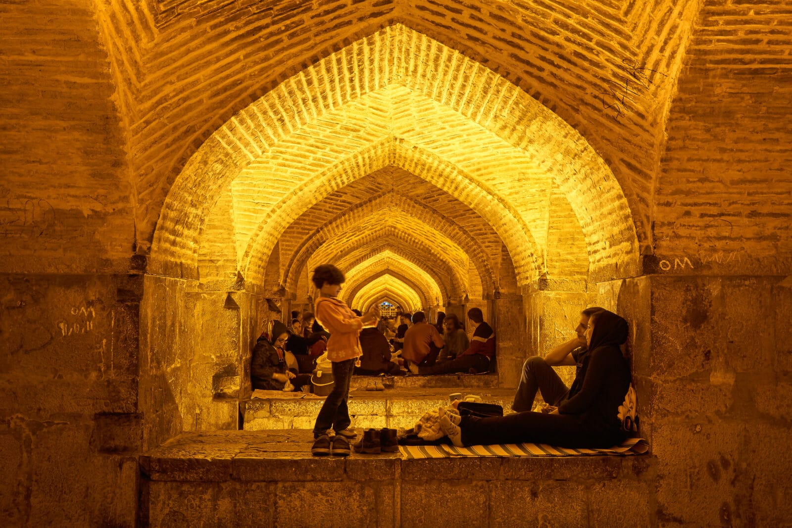Rust onder de bogen van de Khaju-brug in Isfahan