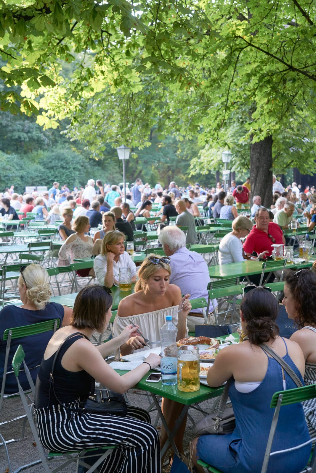 Buiten eten en drinken onder de bomen bij de Kleinhesseloher See, München