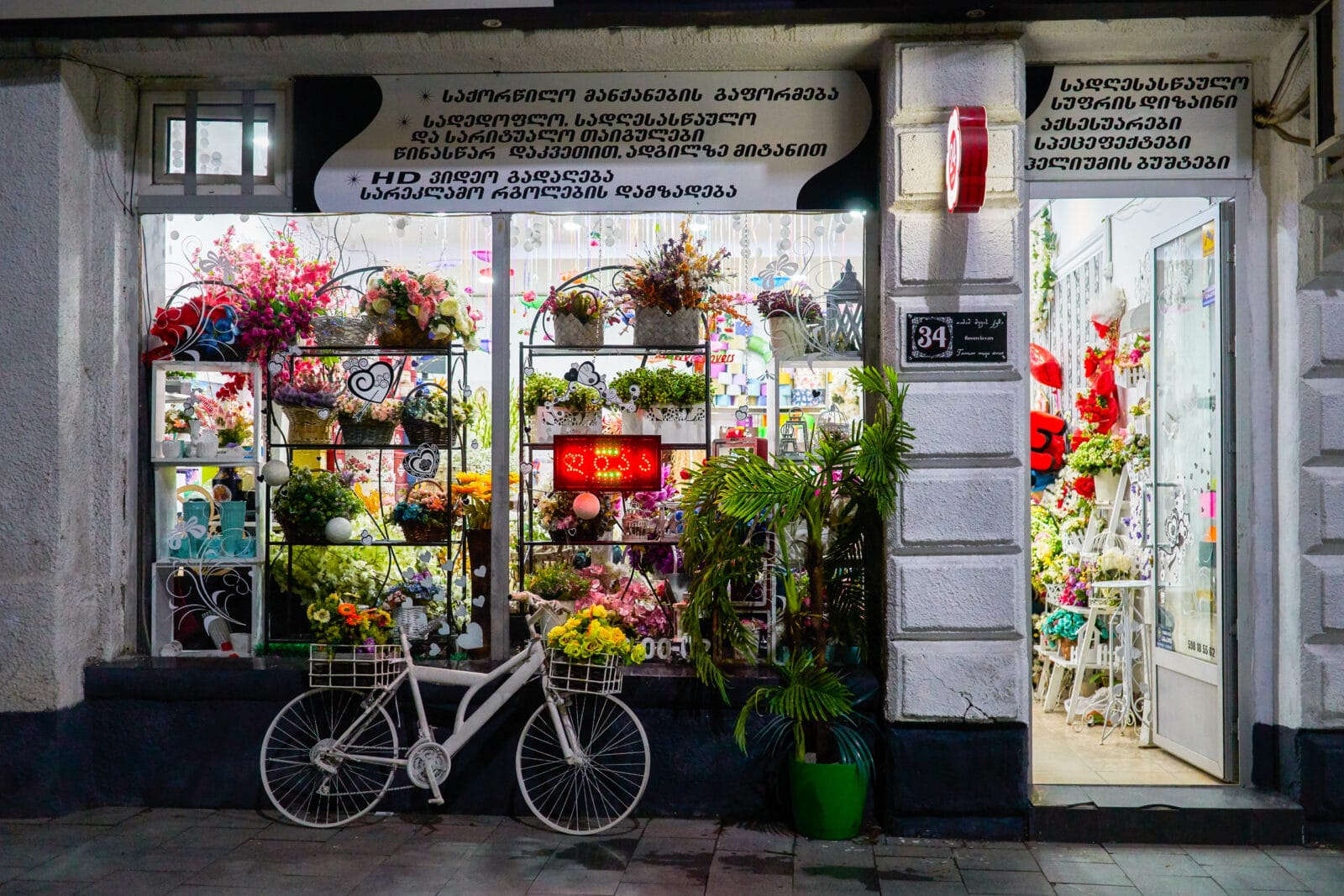 Met bloemen versierde fiets voor een winkel in Koetaisi