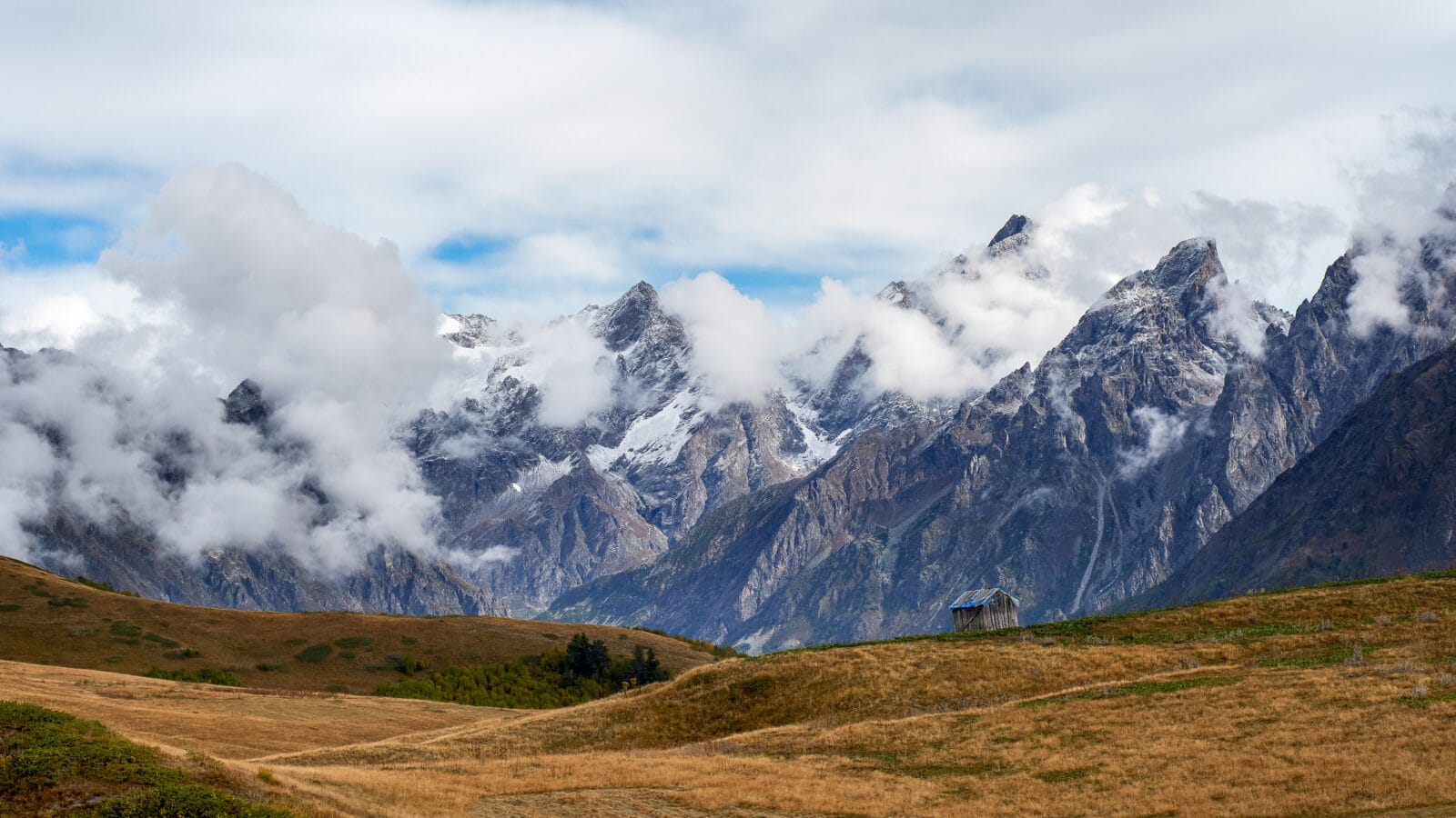 Eenzame hut in het mistige berglandschap boven Mestia