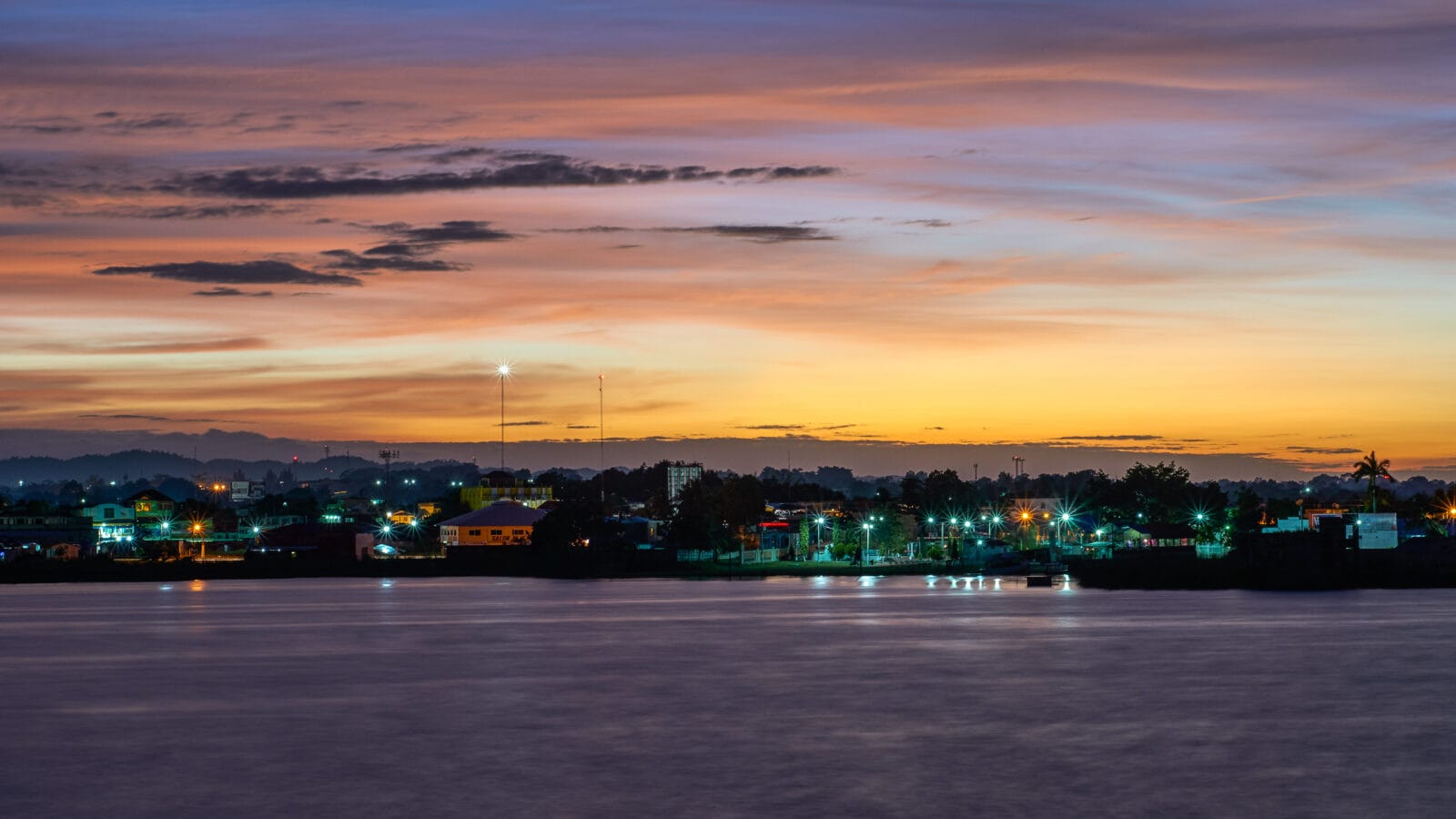 Avondrood boven het Petén Itzámeer met de lichten van San Benito