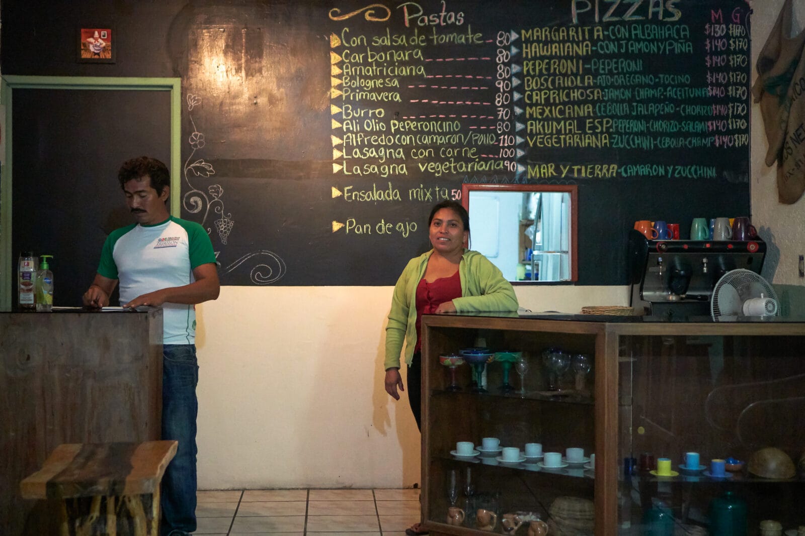 Personeel bij het krijtbord met de menukaart in een restaurantje in Akumal