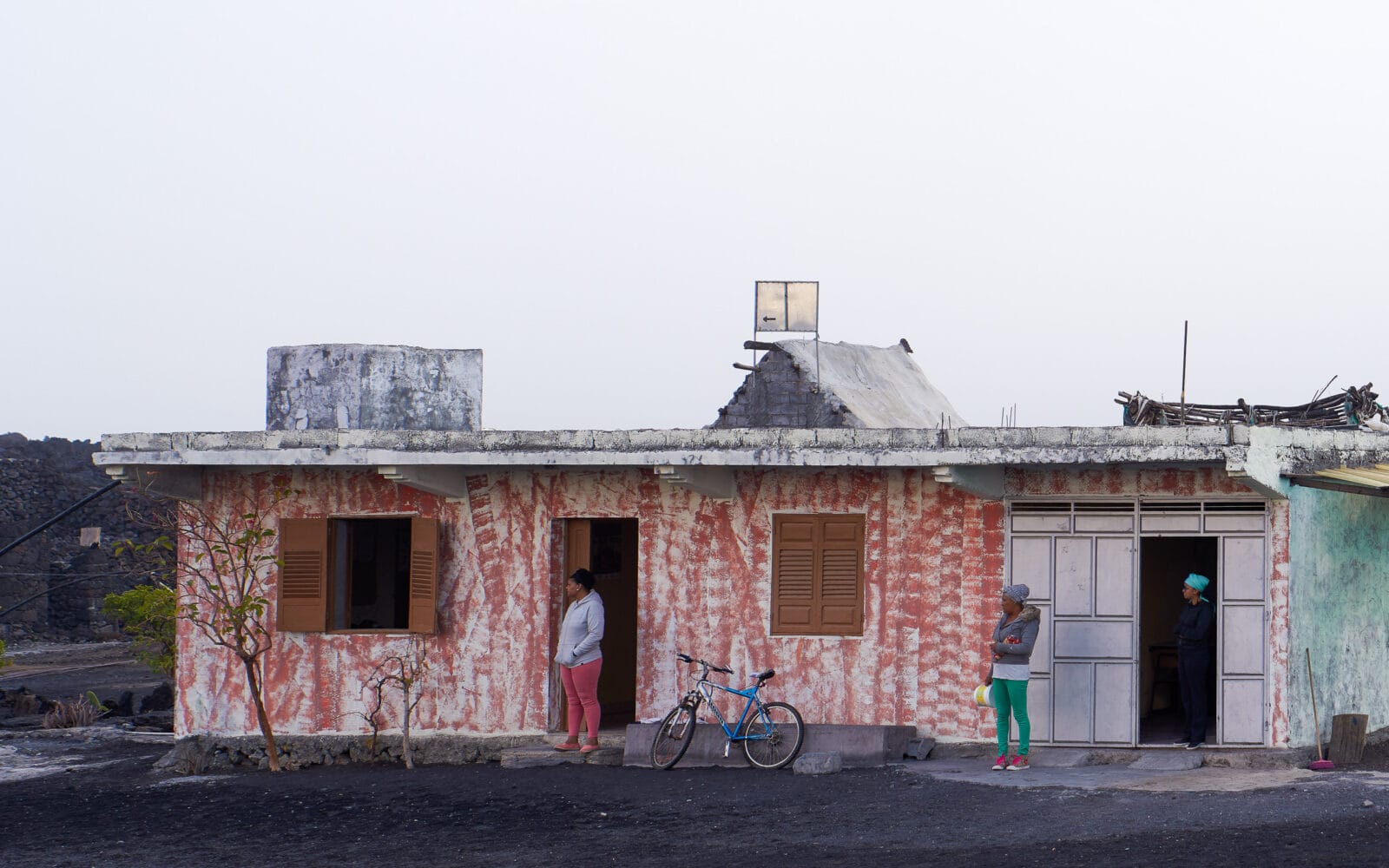 Bewoners voor een verweerd huis in Portela