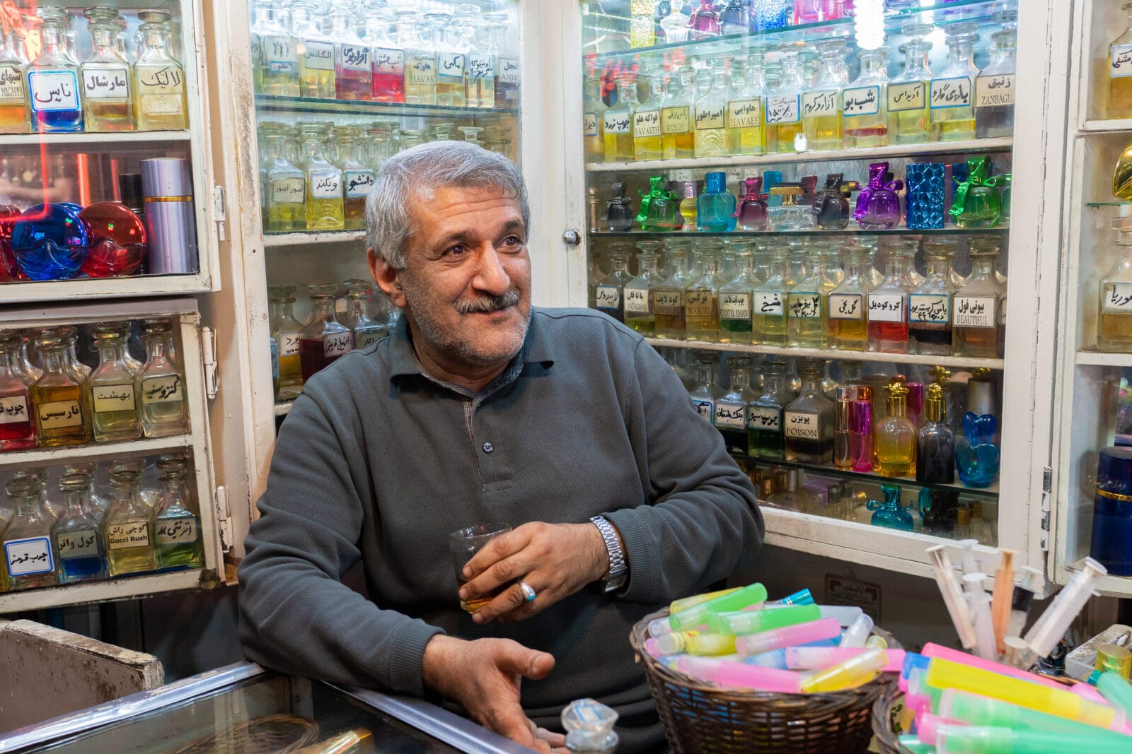 Man in zijn winkel met parfumflessen in Tabriz