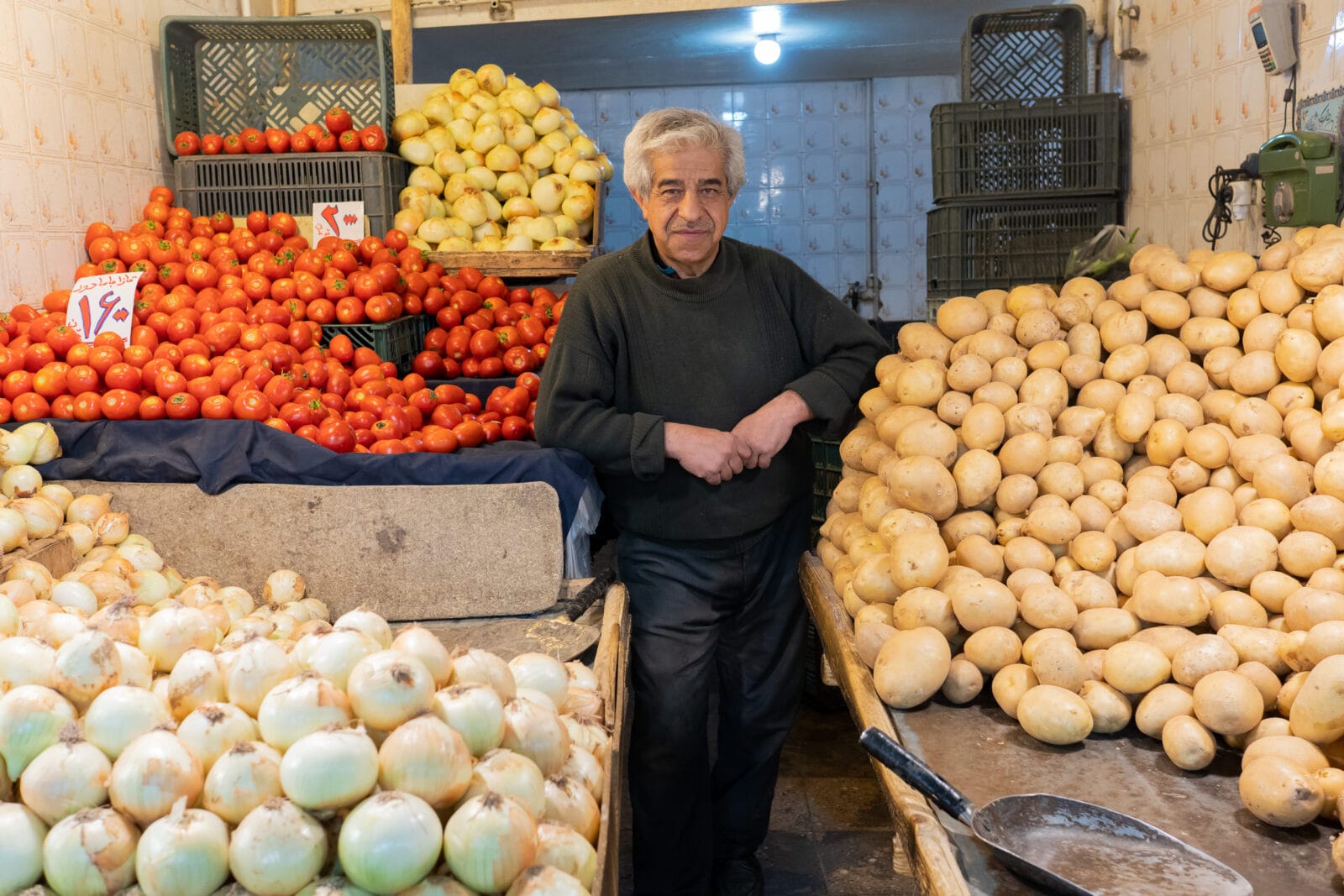 Marktkoopman tussen zijn verse waren in Tabriz