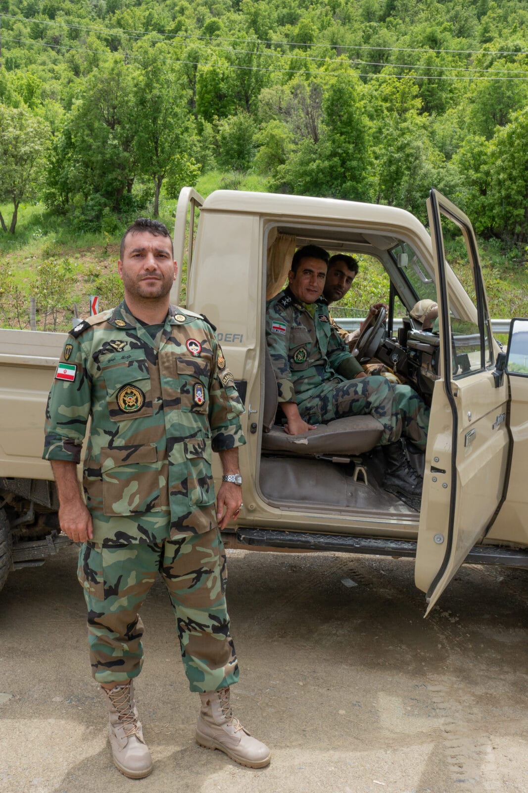 Soldaten bij hun voertuig in het bos bij Marivan