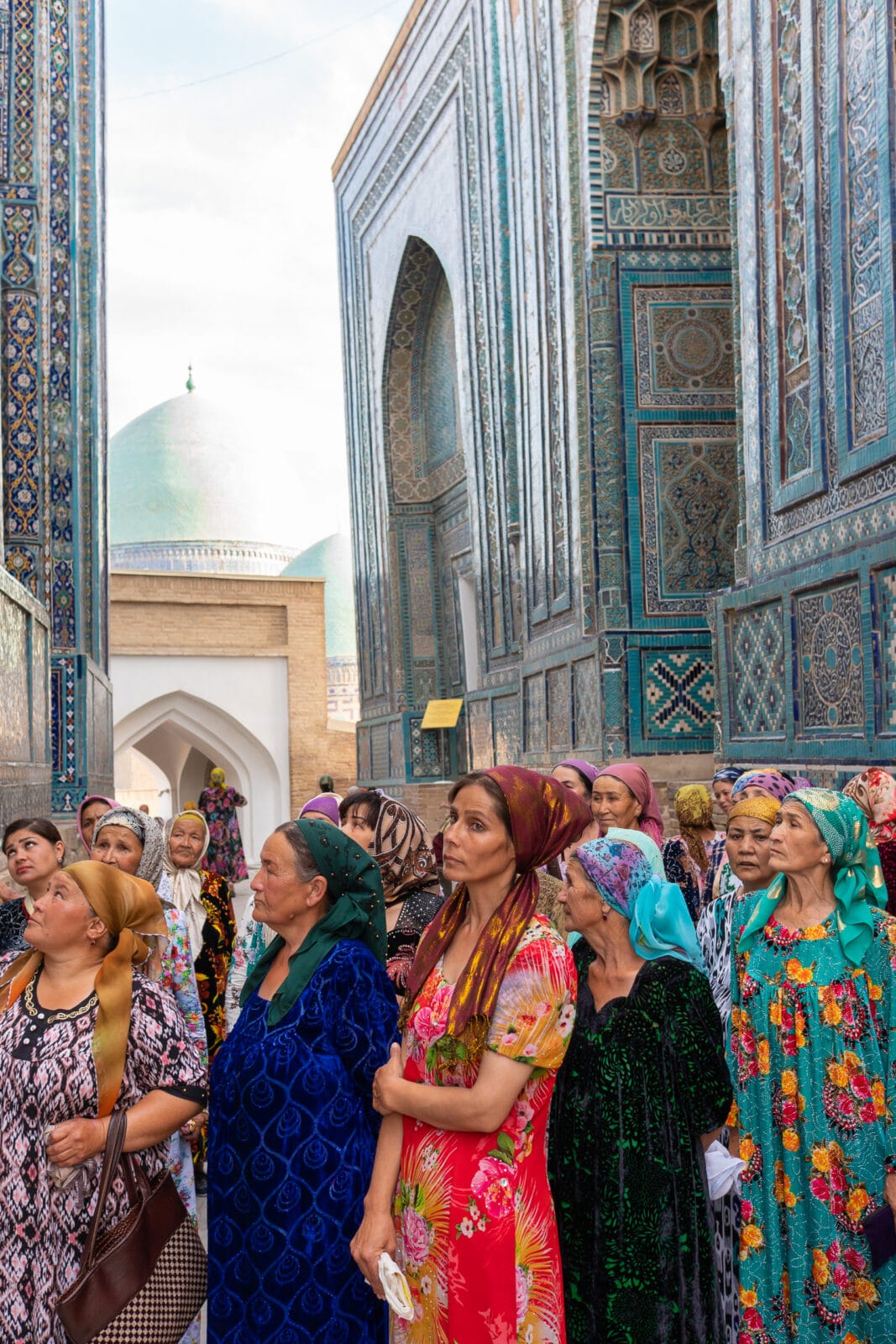 Vrouwen kijken omhoog naar het tegelwerk van de Sjah-i-Zinda in Samarkand