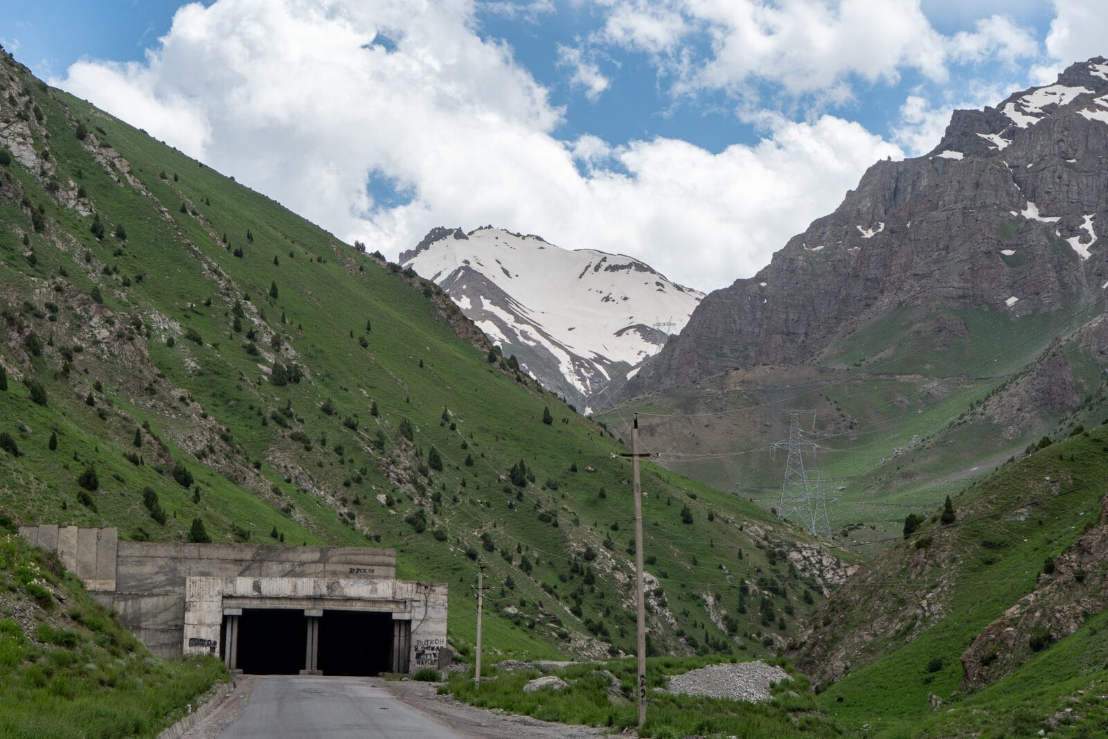 De ingang van de Anzob-tunnel in het groene bergdal