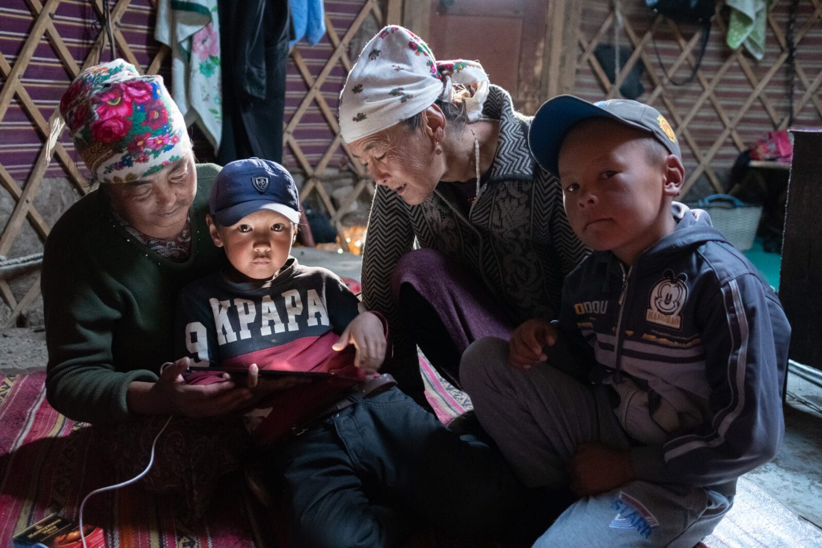 Familie om een tablet in een joert op de Pamir-hoogvlakte