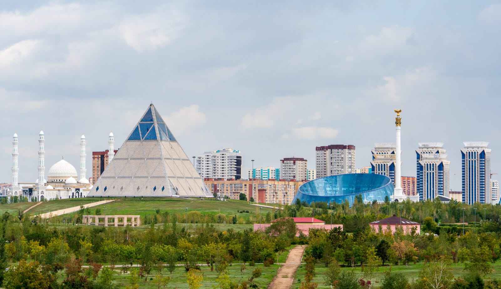Moderne torens boven het groen van een park in Astana