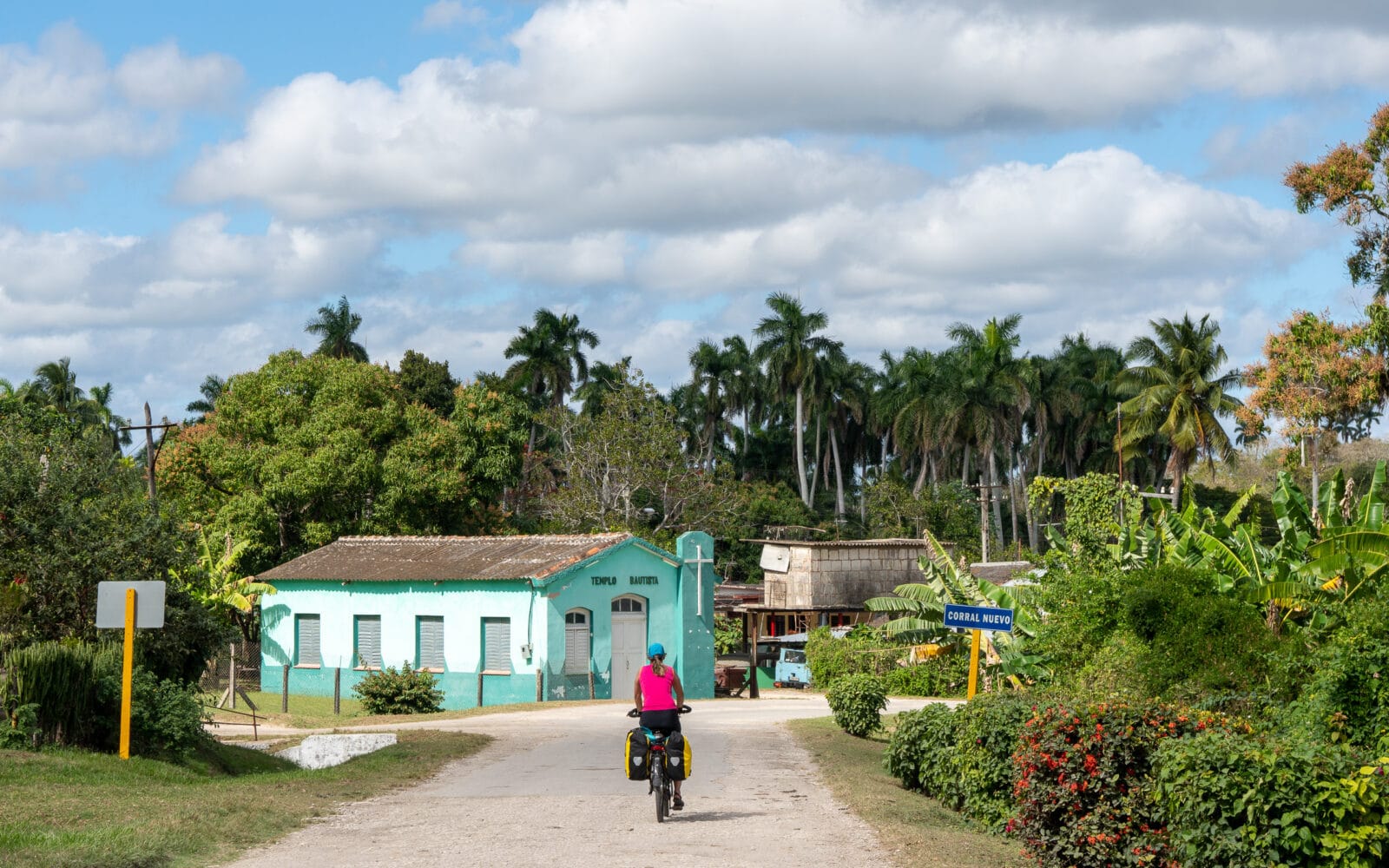 Fietser passeert een turquoise huis in Corral Nuevo bij Matanzas