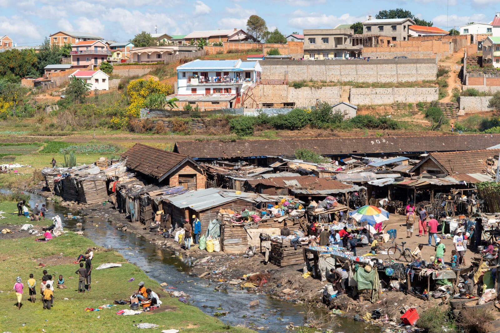 Kinderen spelen bij een vervuilde rivier in Antsirabe
