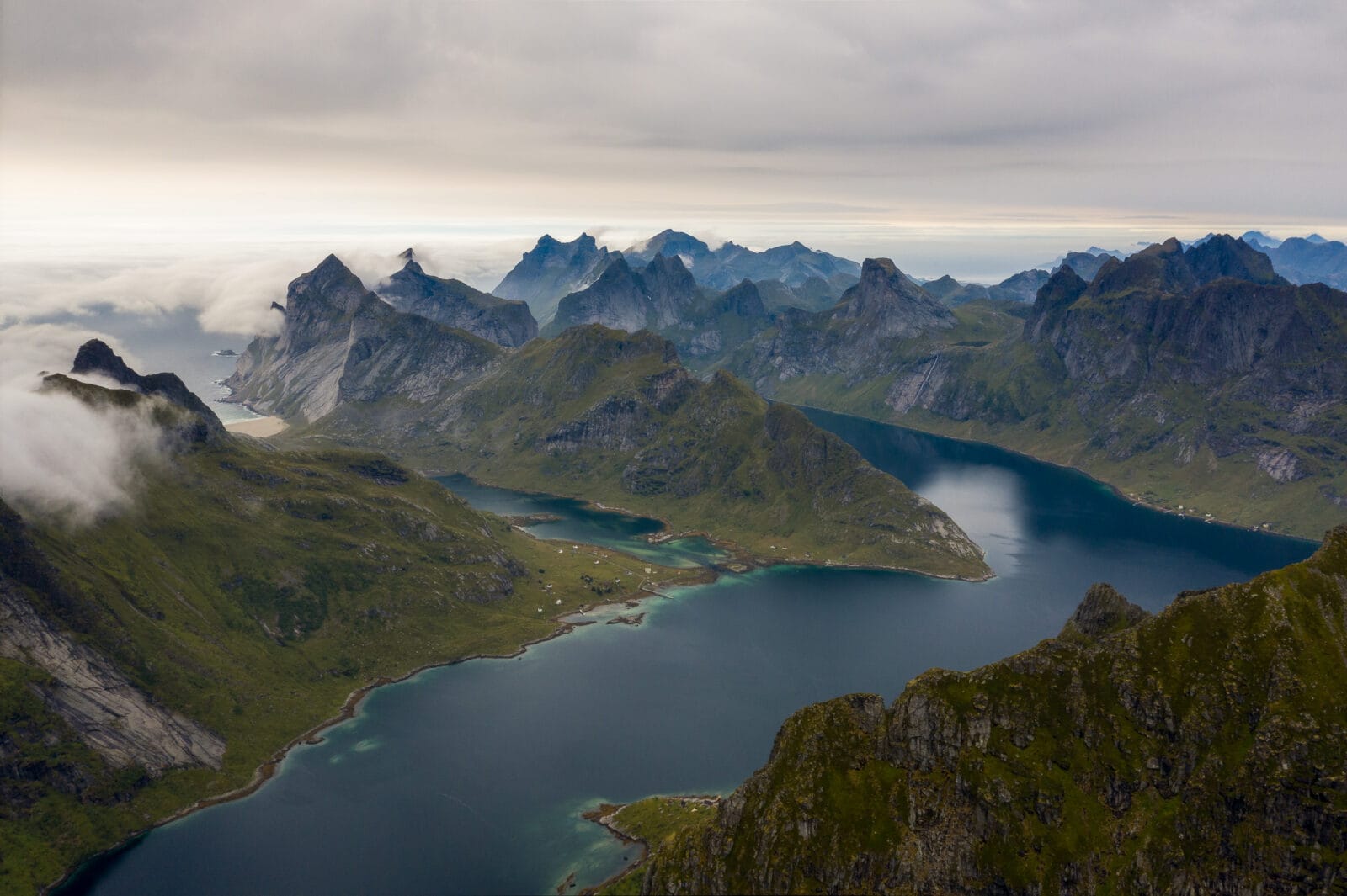 Scherpe bergtoppen boven de wolken bij Munkebu op de Lofoten