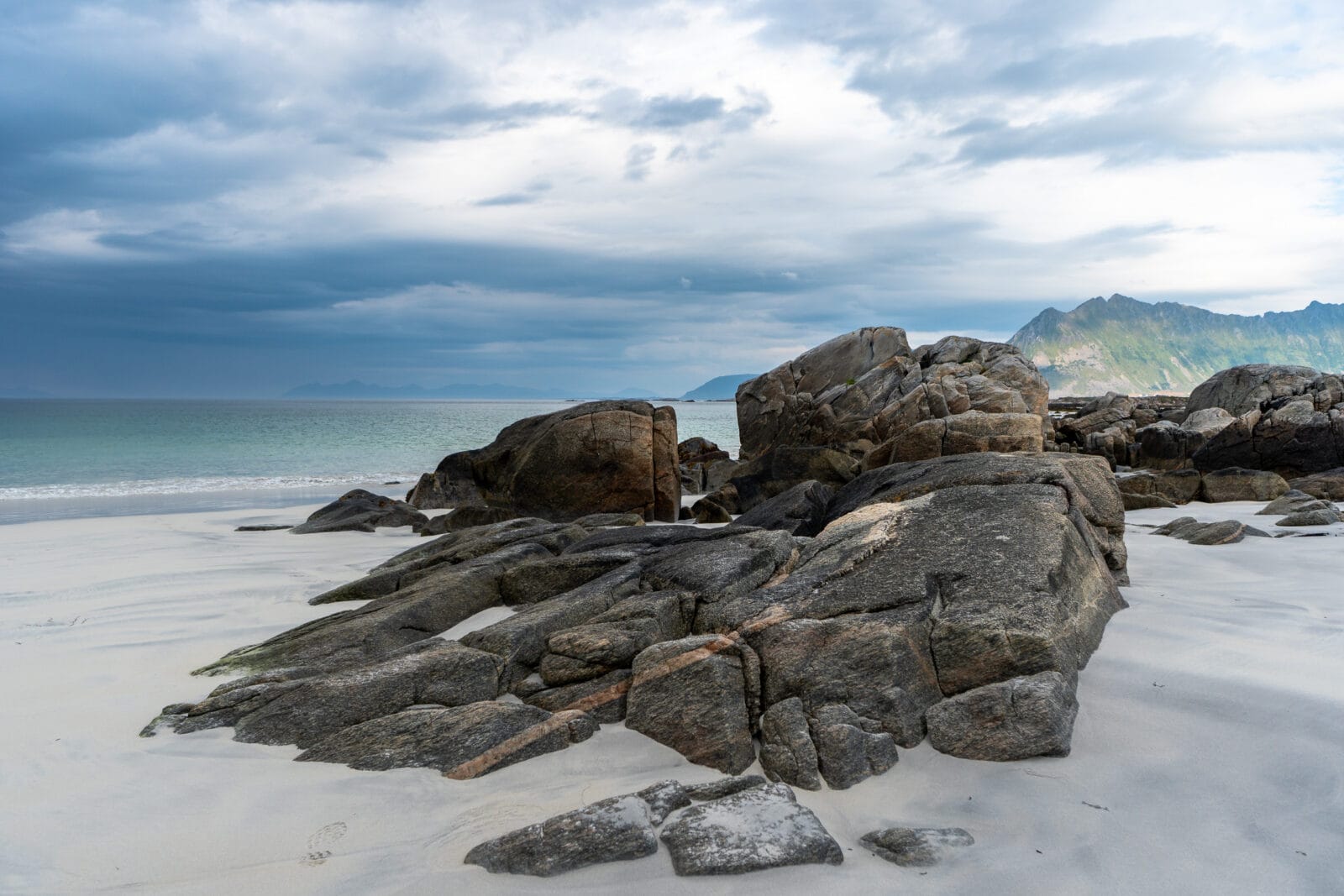 Zware wolken boven het stenige strand aan de noordkust van Vestvågøy