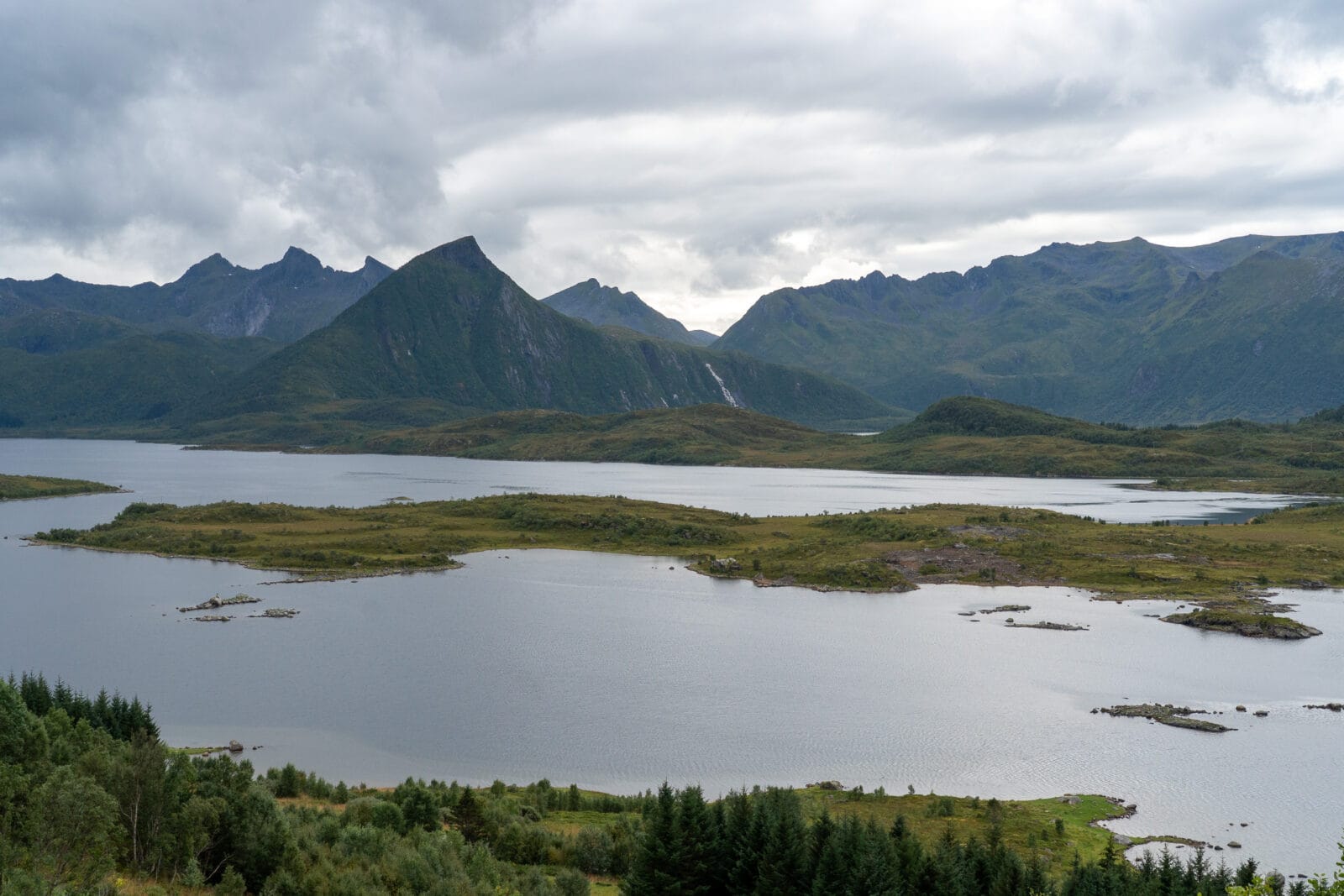 Mistige bergen boven een stil meer bij Laukvik op Austvågøya