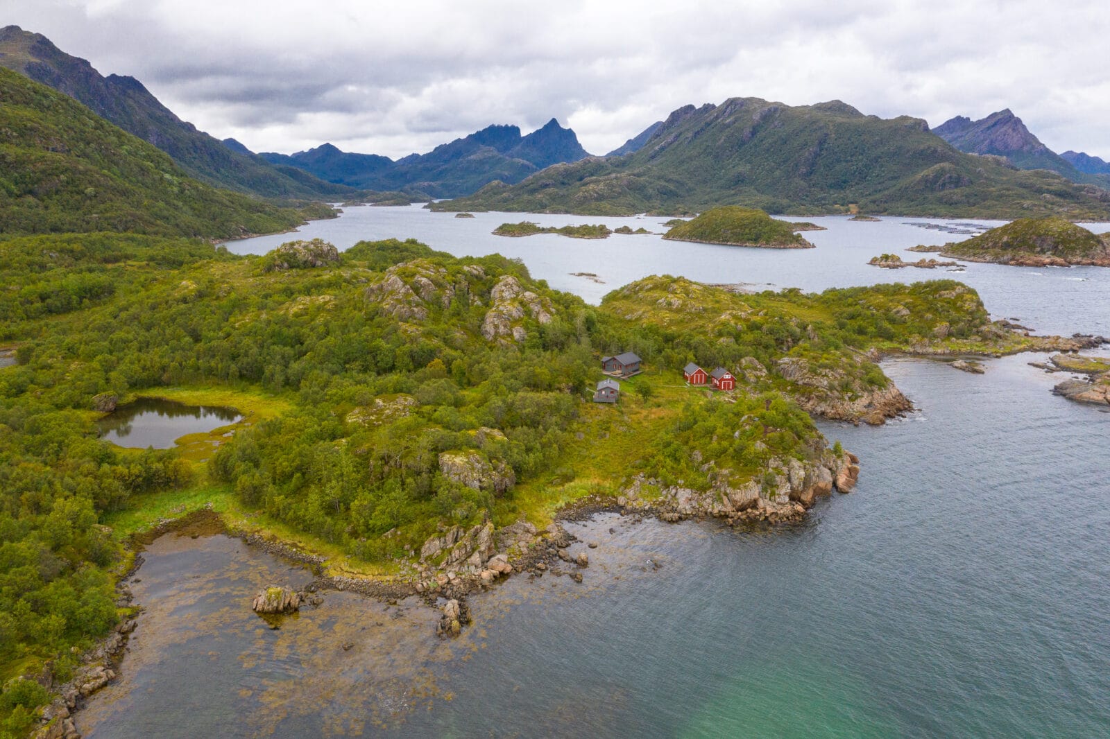 Afgelegen rode hutten in het groene landschap van Bø op de Vesterålen, van boven